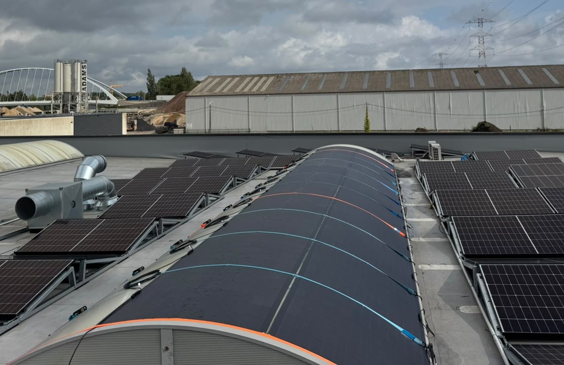 Vista cercana de m&oacute;dulos solares flexibles siguiendo la curvatura de la cubierta, con cables MC4 a ambos lados
