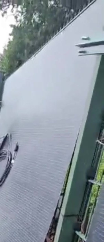 Un panel solar flexible LIONSHEE elevado contra un poste de la valla durante la instalaci&oacute;n