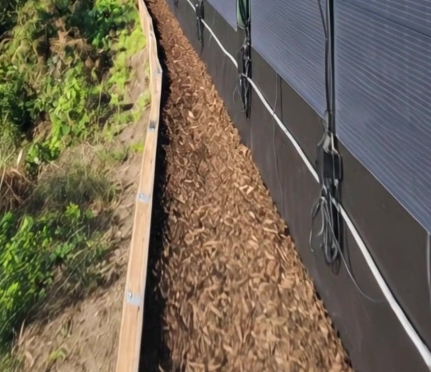 Cables de salida MC4 de paneles solares flexibles verticales a lo largo de la parte inferior de una valla de jard&iacute;n